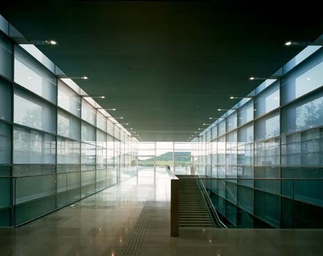 The translucent glass double skin diffuses a quiet brightness through the wide communicating areas. The storage zone is concentrated in the basement floors