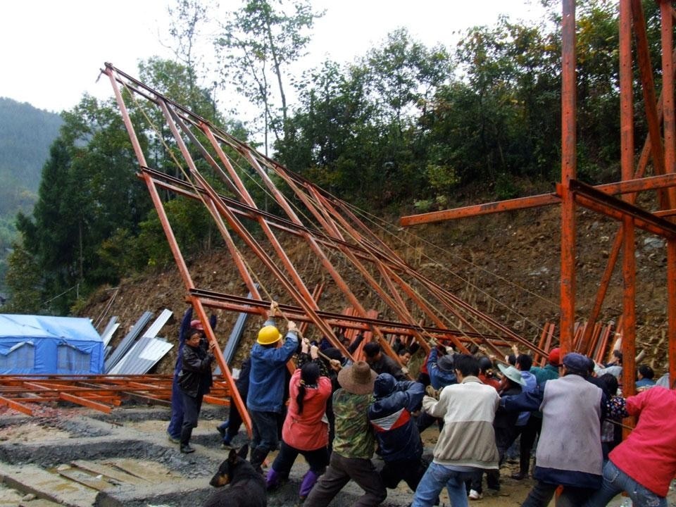 Gli abitanti del villaggio innalzano una struttura in acciaio, LiPing, Sichuan. Photo Hsieh Ying-Chun, Rural Architecture Studio e Atelier 3

