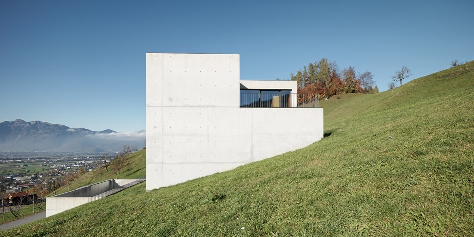 A monolithic concrete house confronting the Alps