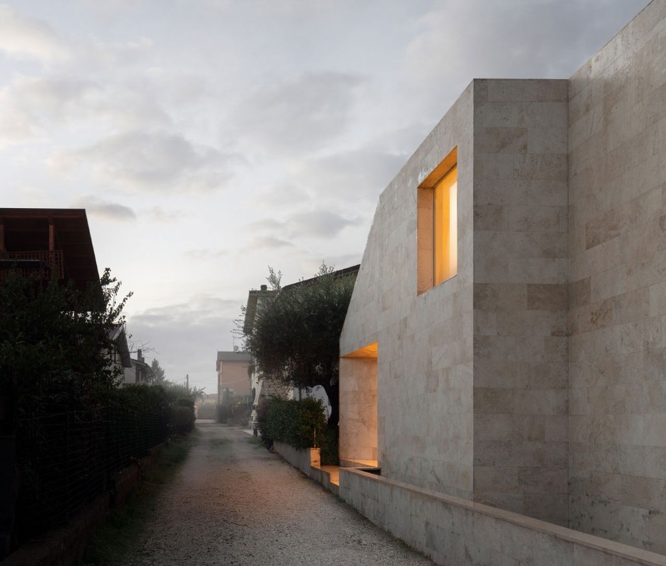 A small house clad in travertine on the outskirts of Rome