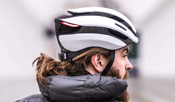 An arm-controlled bike helmet with integrated lights